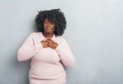 black woman holding hand over her heart