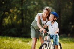 Sister and little brother learning to ride bicycle park having fun together