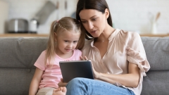 mom with her daughter looking at a tablet