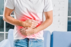 Man holding stomach due to stomach pain and burning