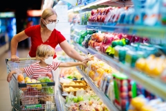 mom and son wearing masks and picking food at the grocery store