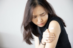 woman with sore arm near vaccine injection site