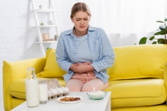 Tired woman with allergy looking at food on table