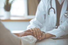 Hands of unknown woman-doctor reassuring her female patient, close-up. Medicine concept