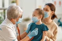 Doctor, child and mother wearing facemasks during coronavirus 
