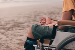 Handicapped children in wheelchairs hold their parents' hands