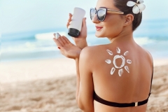 Woman Applying Sun Cream on Tanned Shoulder In Form Of The Sun.