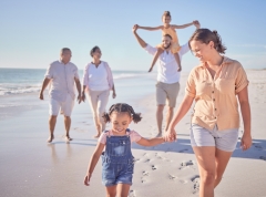  Family, mother and girl holding hands beach on summer holiday.