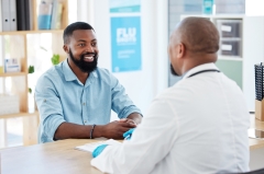 Consulting, patient and happy male with a smile from health communication and expert advice in a clinic