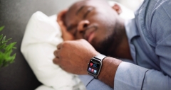 Man Sleeping With Smart Watch In His Hand Showing Heartbeat Rate