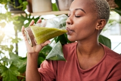 woman drinking green juice