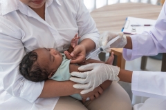 The doctor is vaccinating prevent virus for 1-month-old baby newborn son is half Thai half Nigerian, who is lying on mother's lap, to vaccine for baby and health care concept.