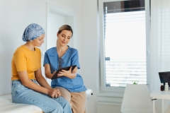 Teenage oncology patient talking with doctor. Oncologist treating teen girl with cancer and provide emotional support, helping her with anxiety and depression.