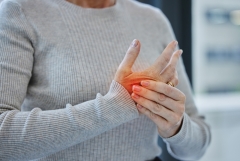 Mature, hands and pain with injury or arthritis in workplace from person, burnout and red glow in office. Tendinitis, parkinsons and muscle fatigue or carpal tunnel syndrome with inflammation.