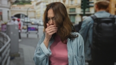 woman coughing outside