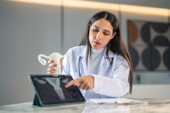 Woman doctor explaining female reproductive system using uterus model, online gynecology consultation, woman health awareness and telemedicine services, telemedicine education, cervical cancer and HPV