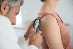 doctor examines patient's skin