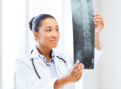 healthcare, medical and radiology concept - african doctor looking at x-ray