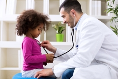 doctor checks younger patient's heart