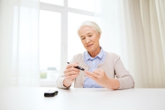 older woman checking blood glucose levels