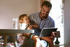 dad with daughter looking at ipad