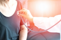 Cardiovascular disease in the elderly concept. Professional doctor using stethoscope with female elderly patient to listen heart and lung to cure chronic disease.