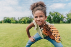 young girl wearing a baseball glove