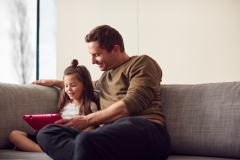 Father with a daughter checking their tablet